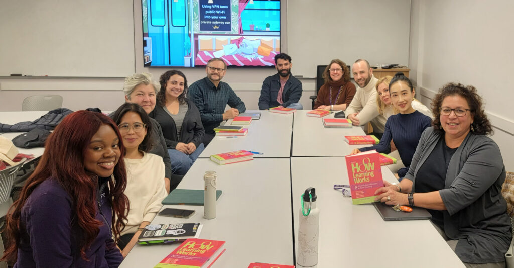 CTL Reads book club attendees show off their books at a bookclub meeting.